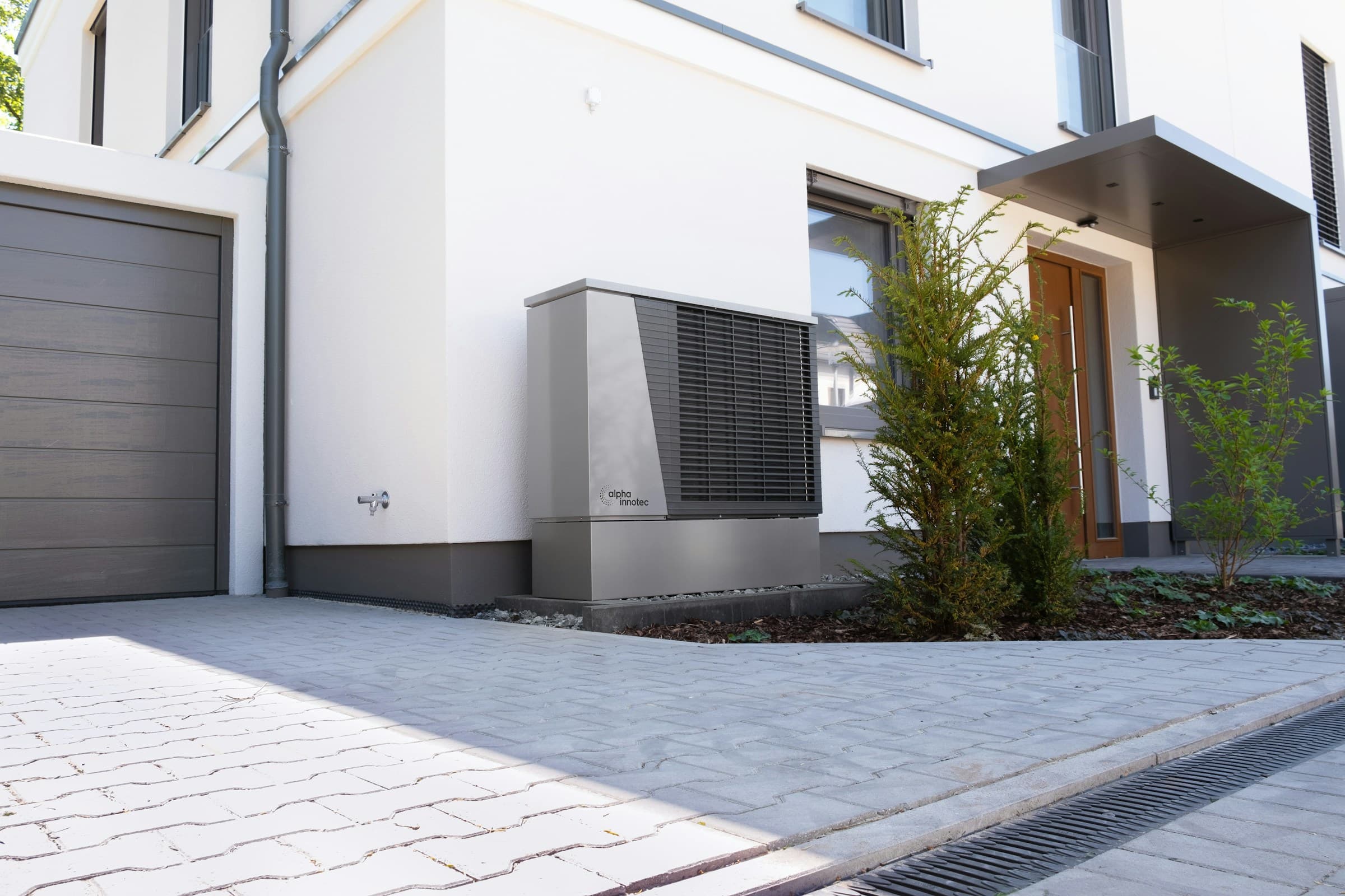 Moderner Neubau mit Wärmepumpe vor dem Eingangsbereich