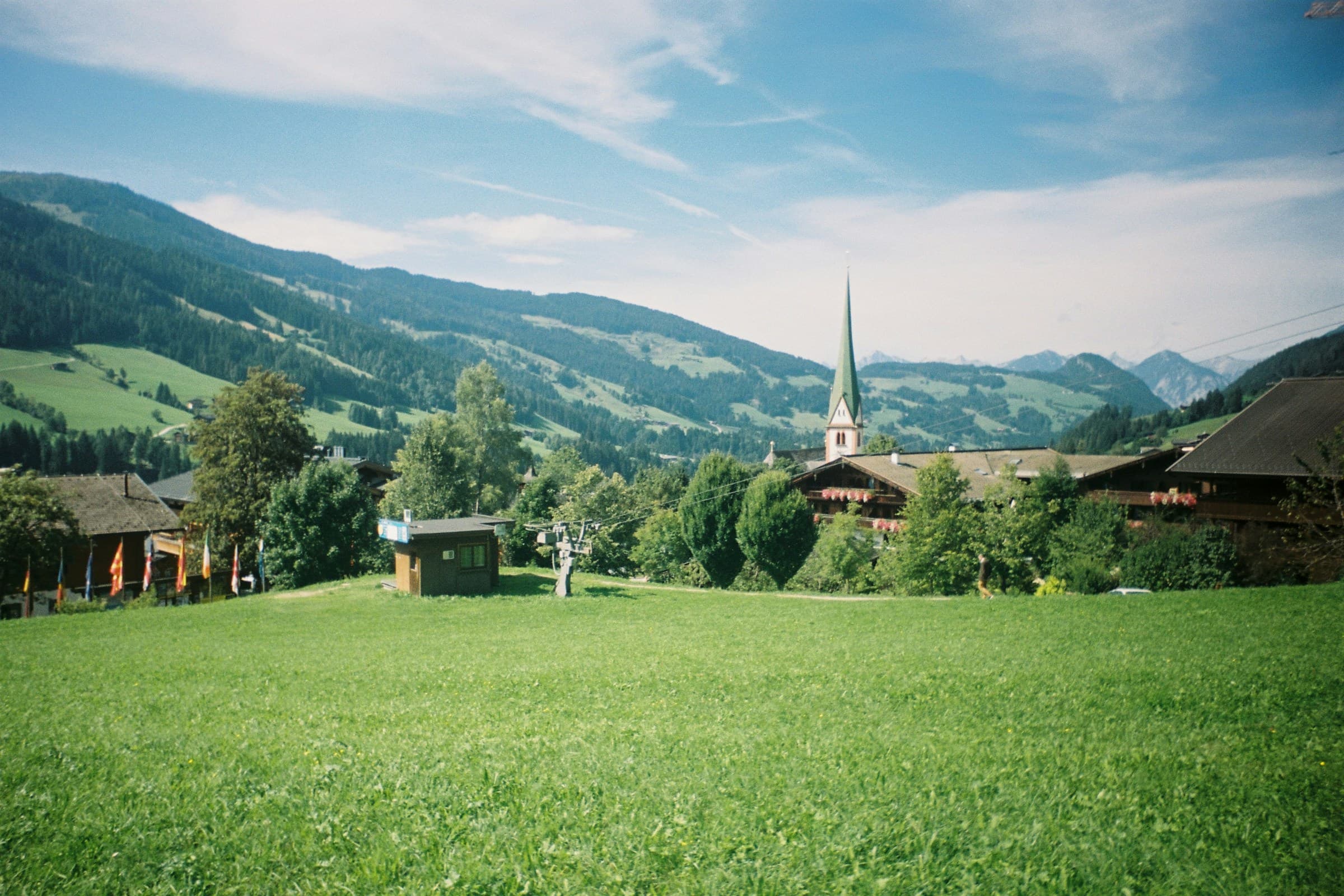 Dorf im Alpbachtal mit Kirchturm und grünen Bergwiesen